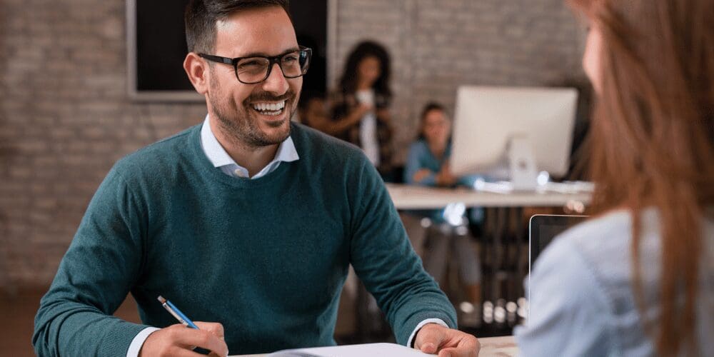 Man and woman at an office talking and smiling