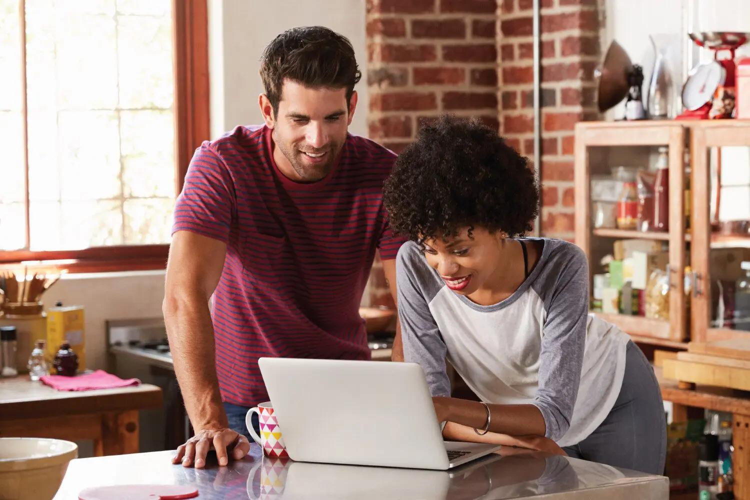 Two people looking at a laptop.