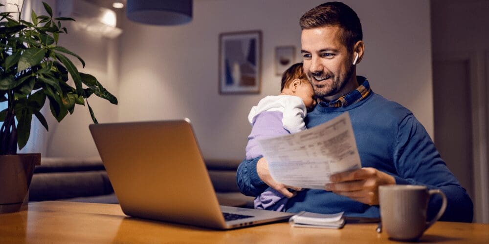 man holding a baby while working