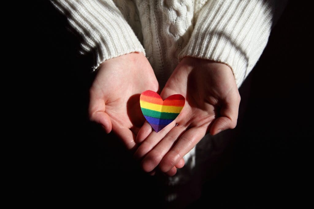 Person holding Pride colored paper heart