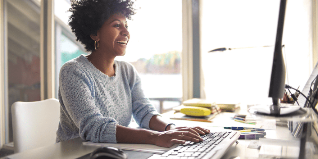 woman smiling while typing