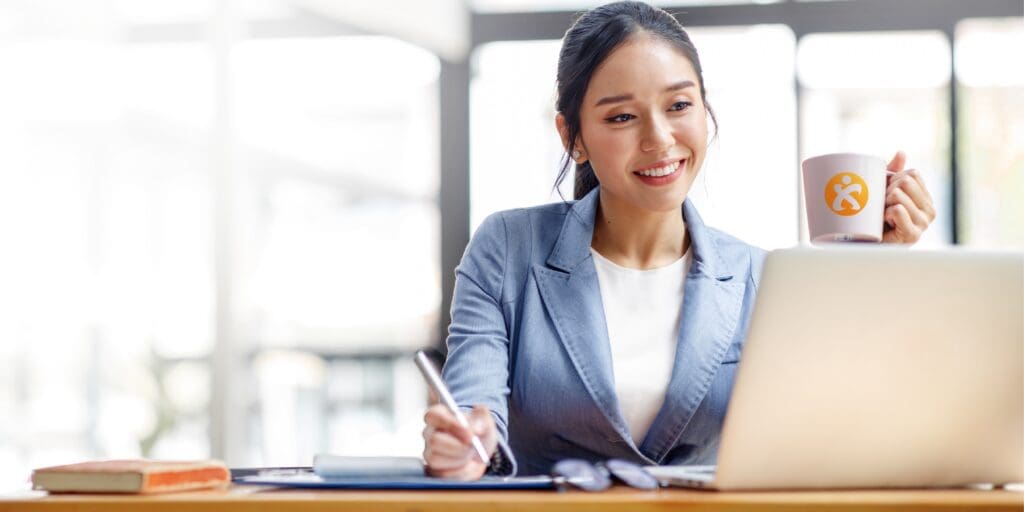 woman holding a mug while taking notes