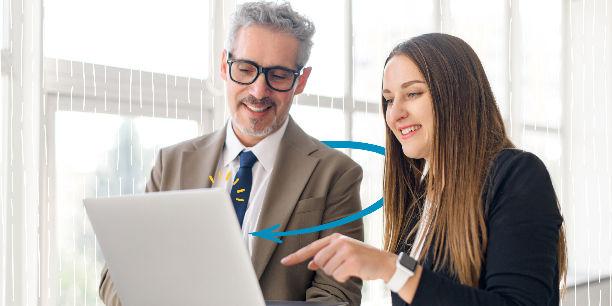 Young Female Professional Points to Screen of a Laptop While a Businessman With a Happy Expression Looks On