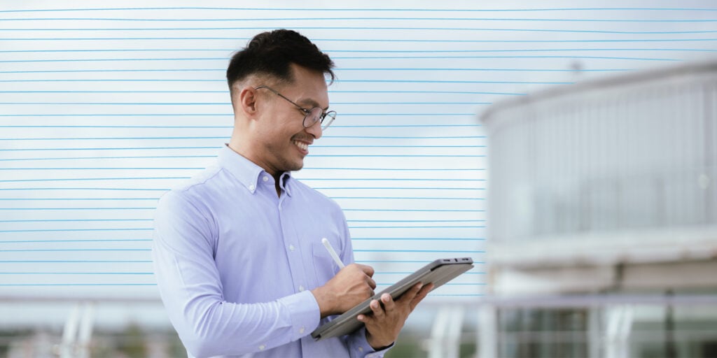 A Confident Businessman Standing in a Modern City, Smiling While Holding a Smartphone