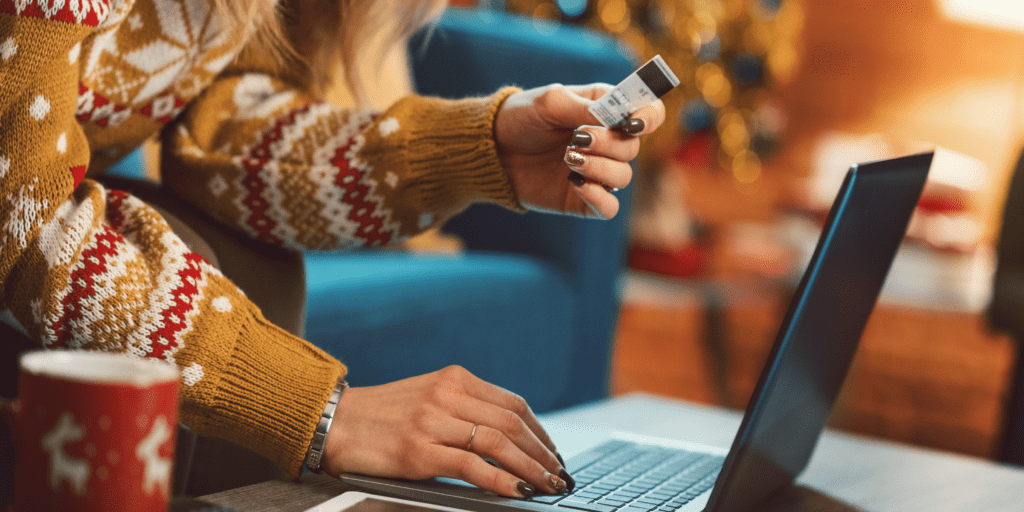 Woman holding a card while typing in a computer