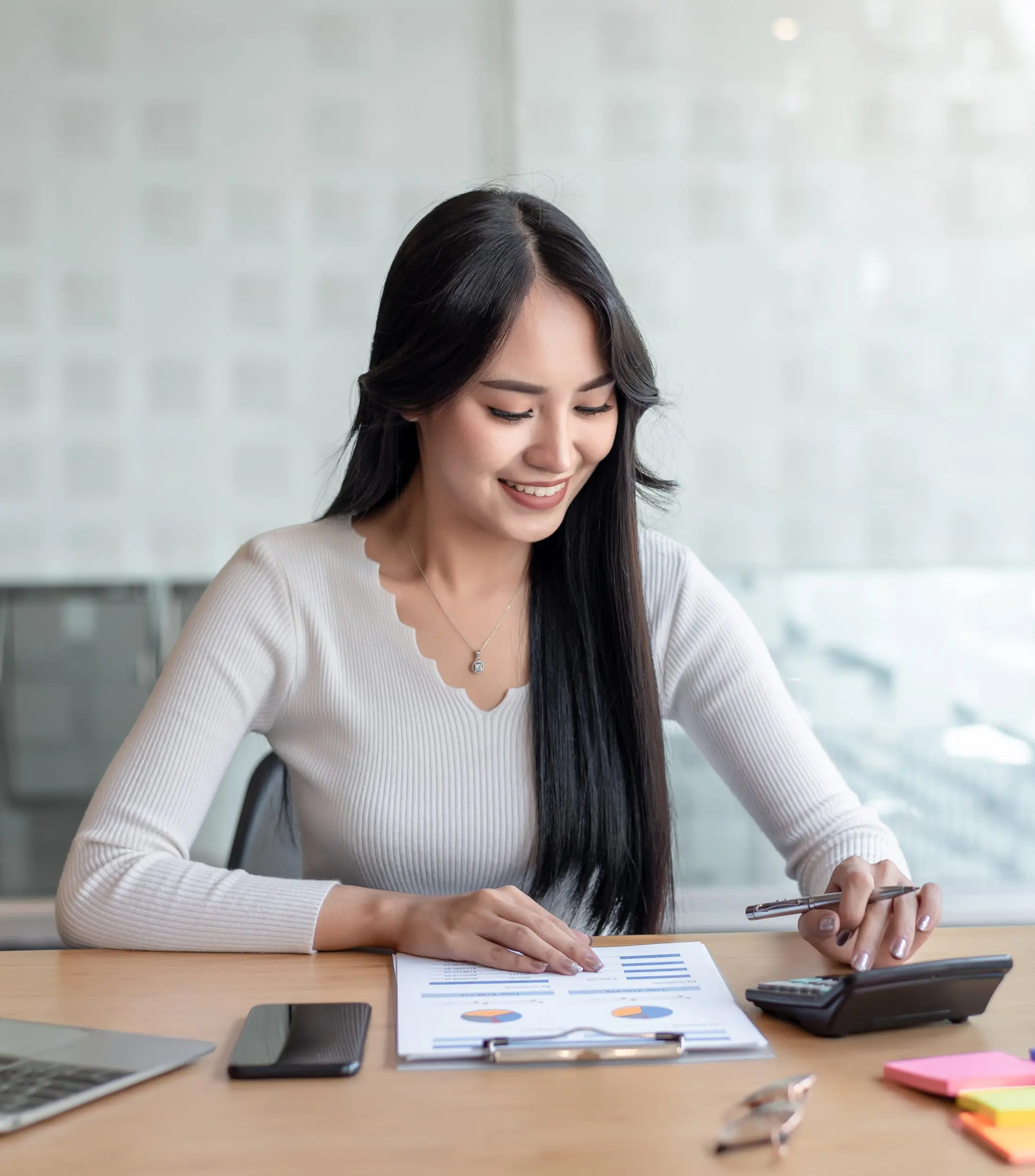 Business Woman Using Calculator on Desk With Documents