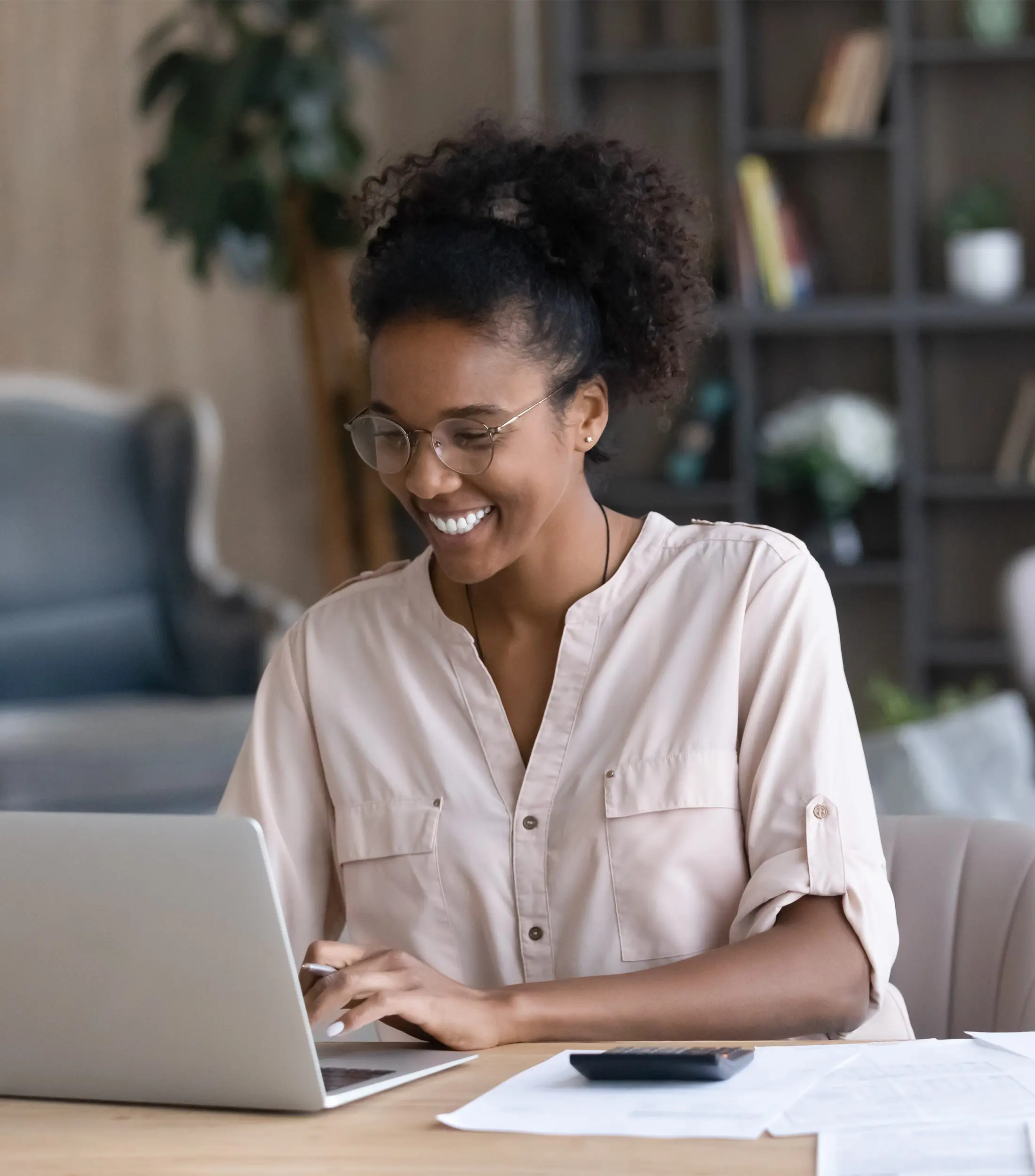 Happy Smiling Woman Managing Budget Using Calculator for Paper Expenses