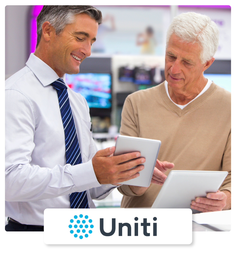 two men talking and looking at a tablet