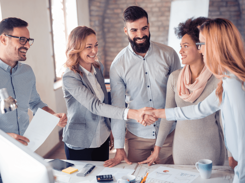 Corporate individuals sealing a deal with a handshake in an office.