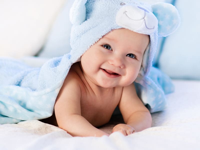 Baby Boy Wearing Diaper and Blue Towel in White Sunny Bedroom – Resource Thumbnail
