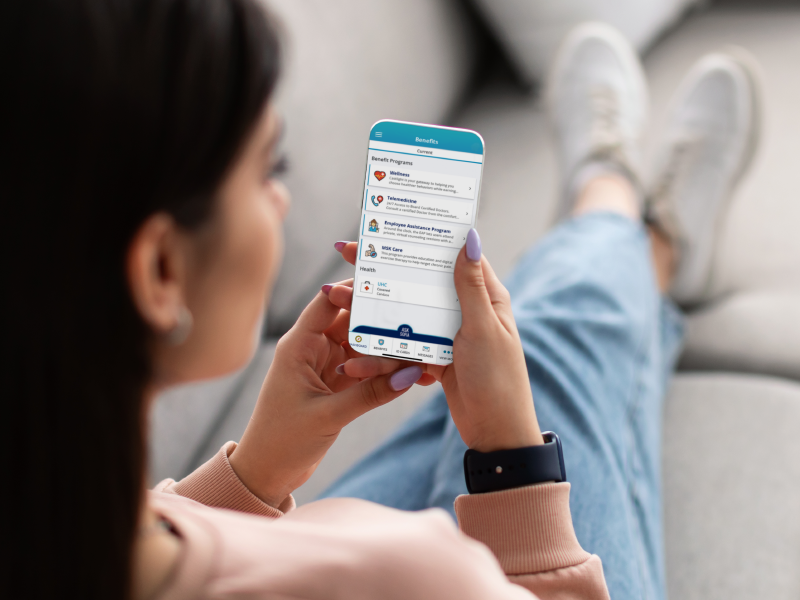 person relaxing looking at their benefits on the phone