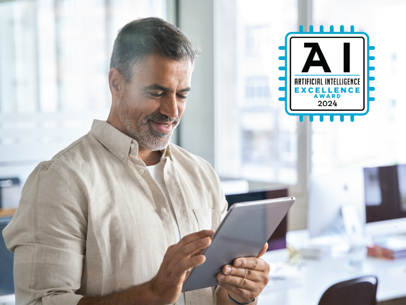 Man looking at tablet in an office with award seal for Best Artificial Intelligence Excellence Award