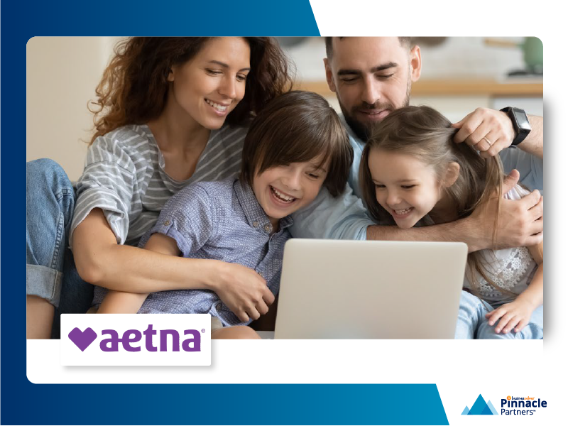 Family looking at a computer smiling enrolling in aetna benefits.
