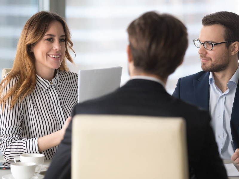 a group of employees having a conversation about business strategies in a conference room
