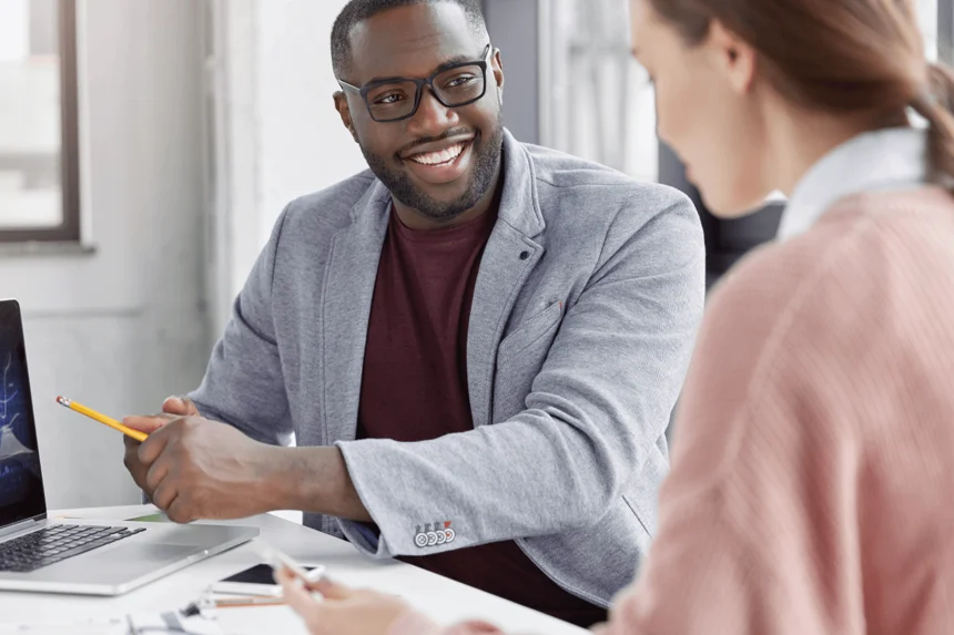 Two people consulting at a table smiling