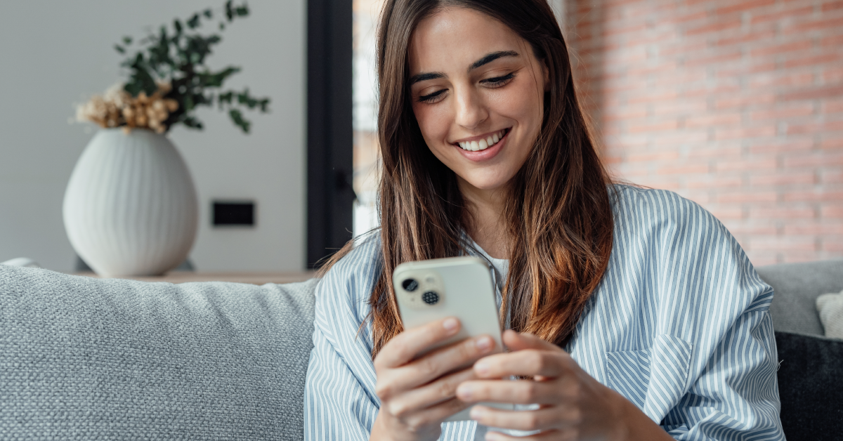 Women at home looking at her phone and smiling