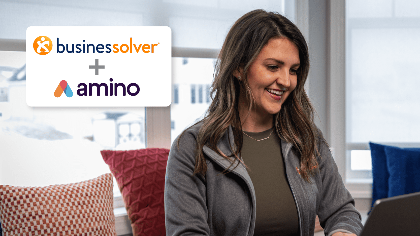 Woman using laptop with Businessolver and Amino Logos