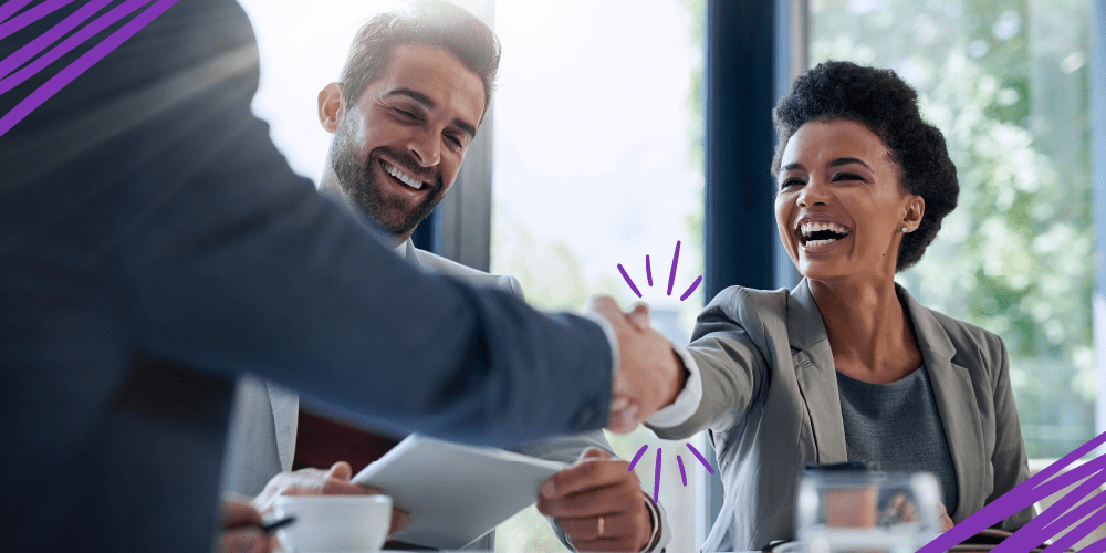 Two colleagues engaged in a handshake at a business meeting, illustrating a moment of agreement and professional connection.