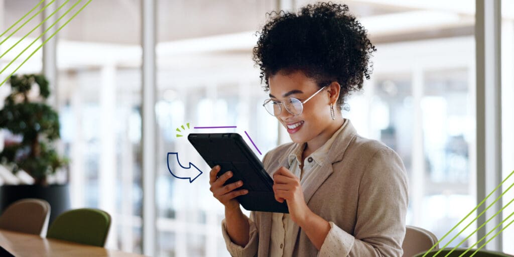 Happy Business Woman Looking at Tablet Working in an Office