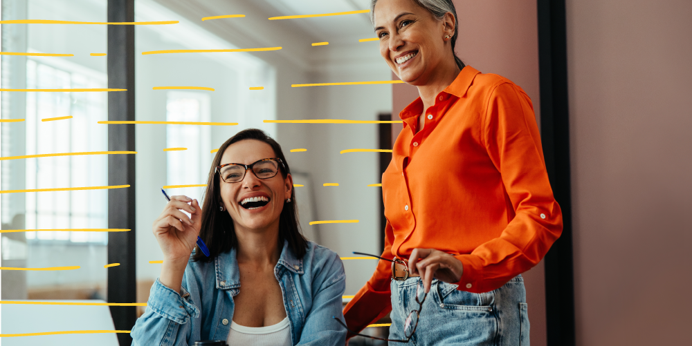 two women at an office smilling